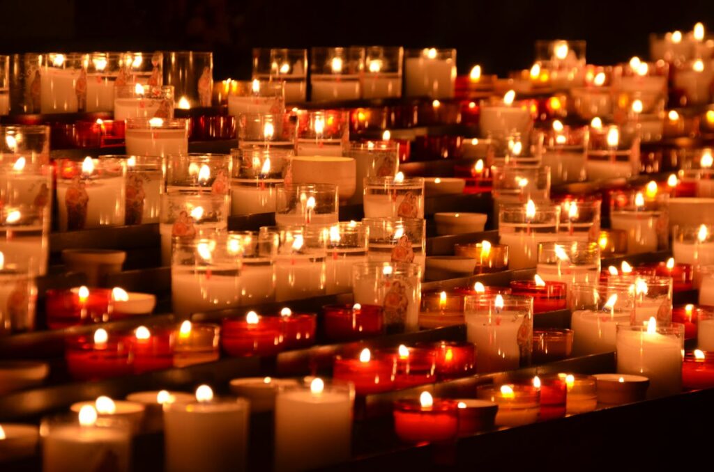 Rows of flickering candles in a chapel setting, evoking tranquility and reflection.