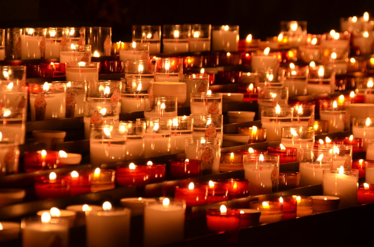 Rows of flickering candles in a chapel setting, evoking tranquility and reflection.